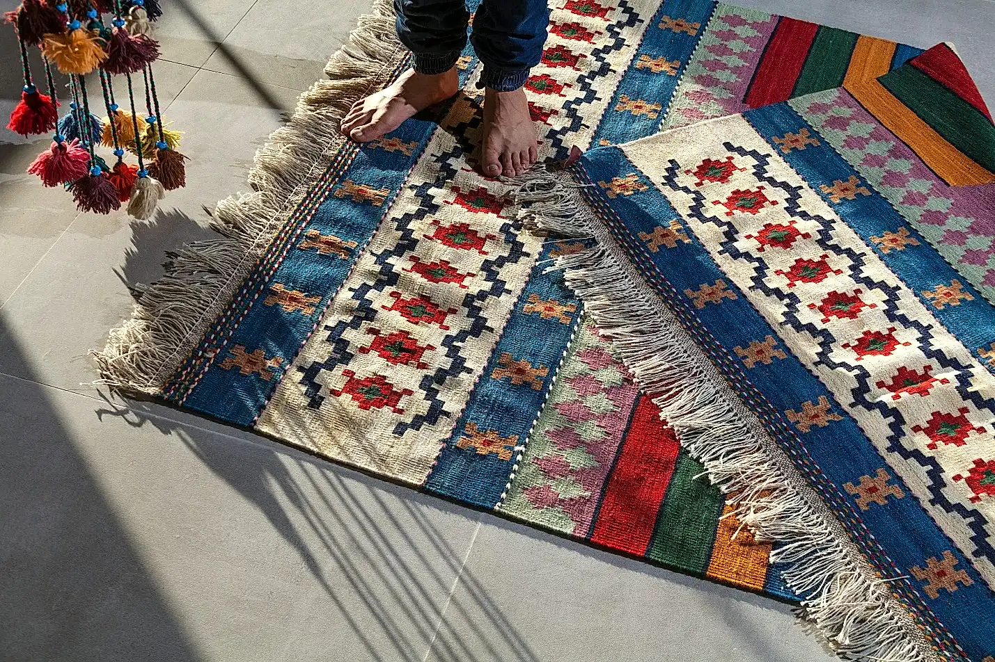 A person standing on a colorful carpet.